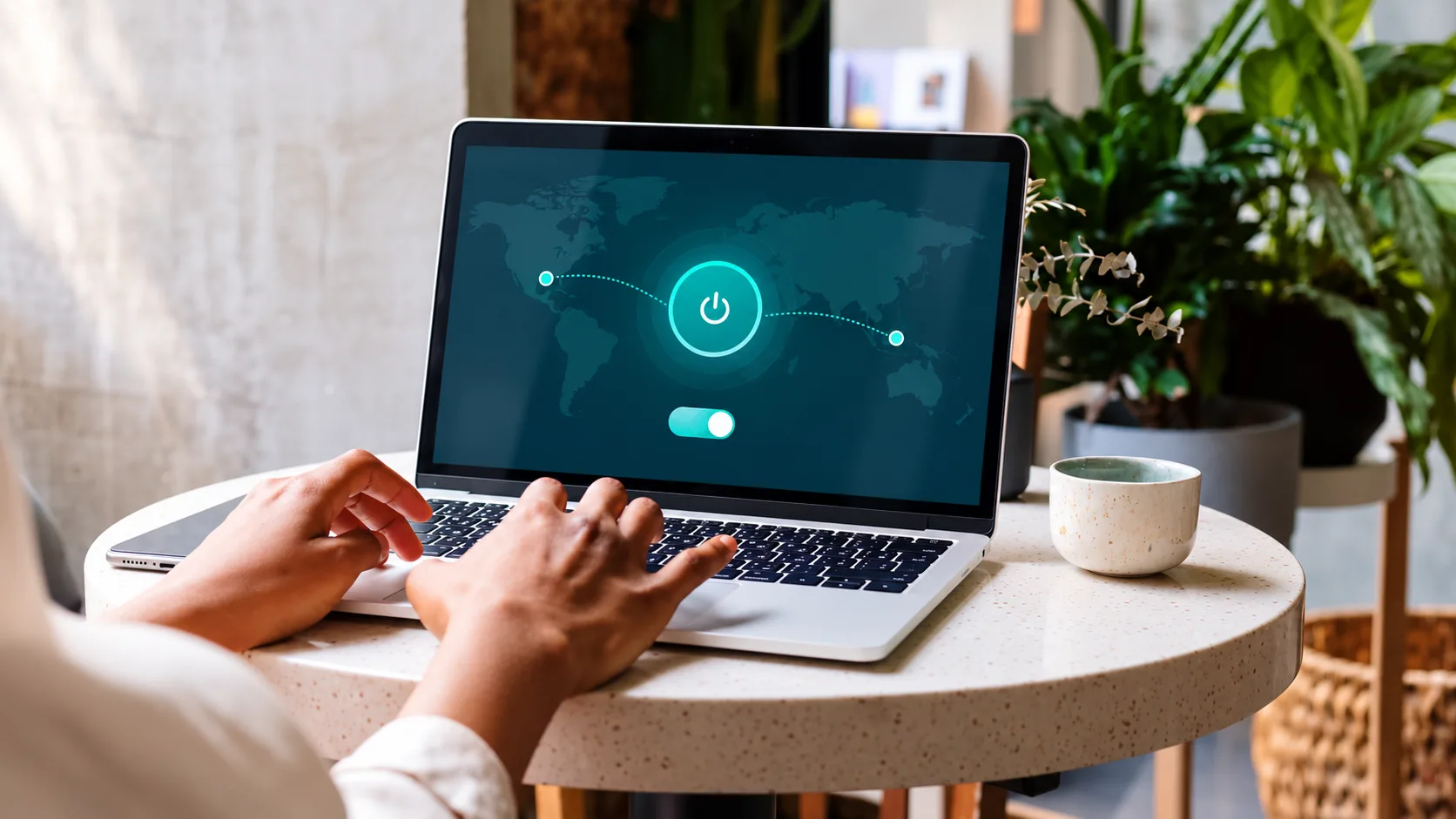 A person setting up a VPN on a MacBook in a caf&eacute;, with an illustrative connection screen